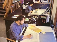 two men working at a desk in an office