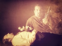 a man is laying on a bed with a flower in his hand