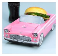 a pink car with a hamburger and coke next to it