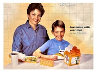 a woman and a boy are sitting at a table with food in front of them