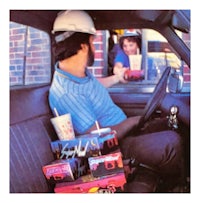 a man in a hard hat sitting in the back seat of a car